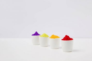 row of colorful holi paint in bowls on white, Hindu spring festival clipart