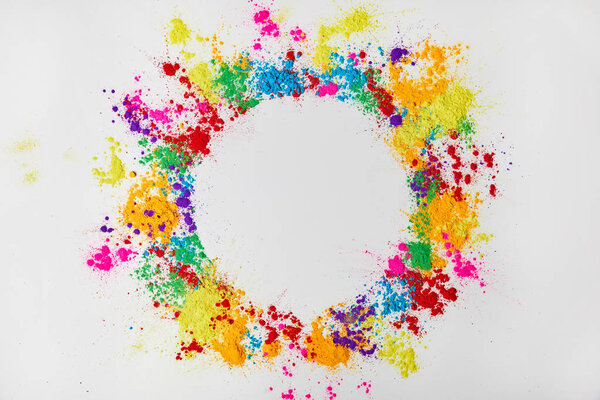 circle frame of multicolored traditional powder, isolated on white, festival of colours