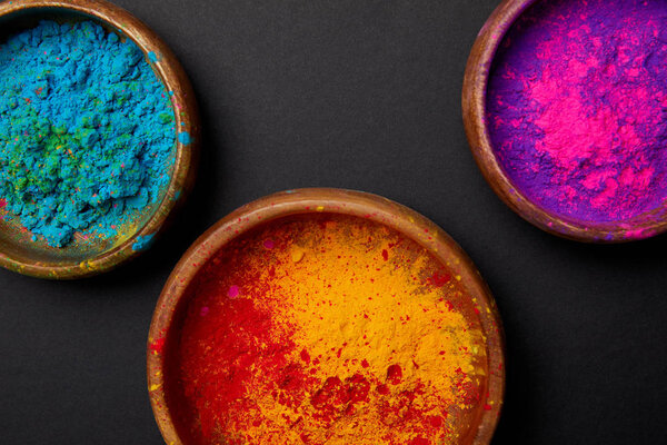 top view of colorful holi powder in paint on grey surface, Hindu spring festival