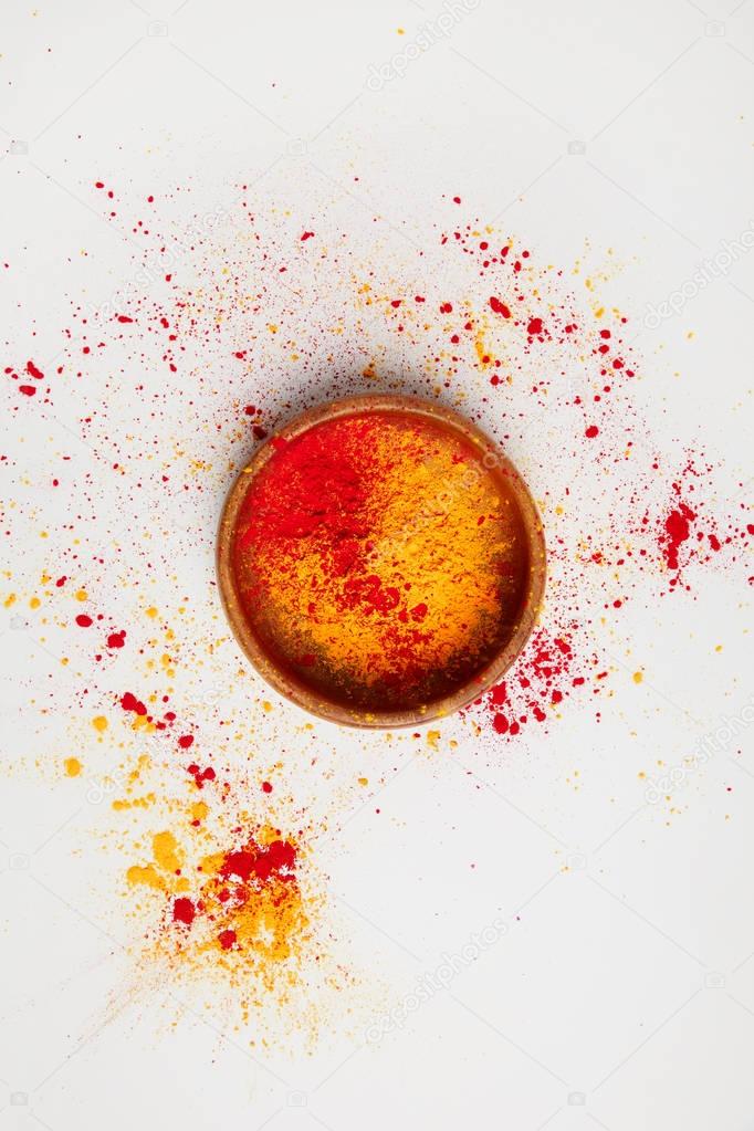 top view of orange and red holi paint in bowl isolated on white, Hindu spring festival