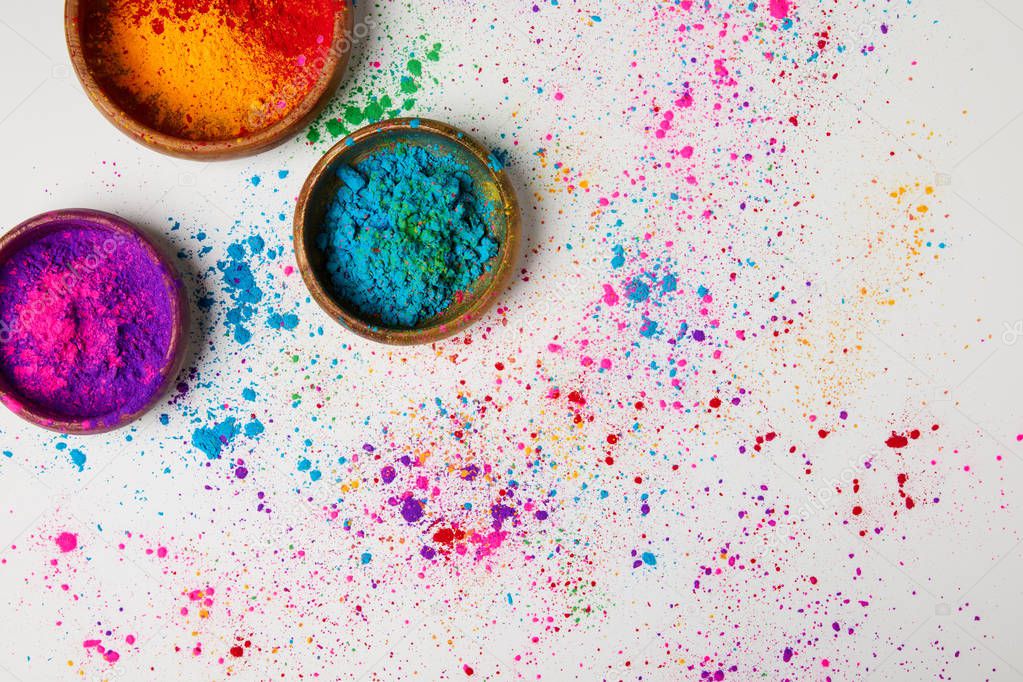 top view of traditional holi paint in bowls isolated on white, Hindu spring festival of colours