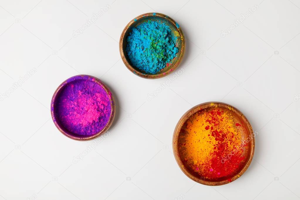 top view of colorful holi powder in three bowls isolated on white, Hindu spring festival