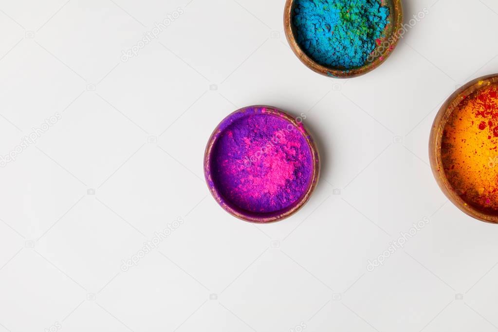 top view of colorful holi powder in bowls isolated on white, Hindu spring festival