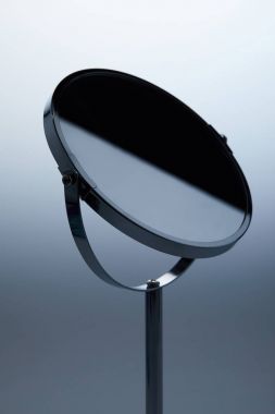close-up shot of cosmetic mirror with stand on grey clipart