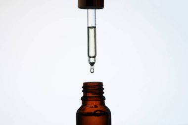 yakın çekim çekim şişe beyaz üzerine pipet ile aromatik yağı