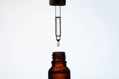 close-up shot of bottle of aromatic oil with pipette above on white clipart