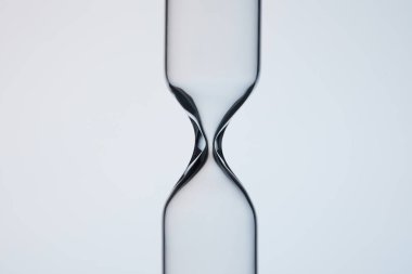 close-up shot of empty glasware in shape of hourglass on grey clipart