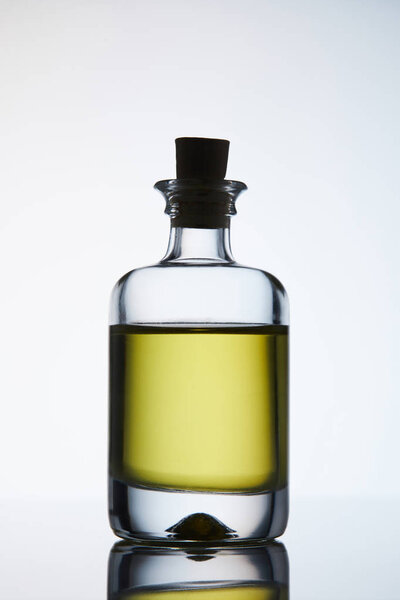 closed bottle of aromatic massage oil standing on reflective surface