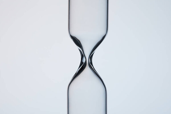 close-up shot of empty glasware in shape of hourglass on grey