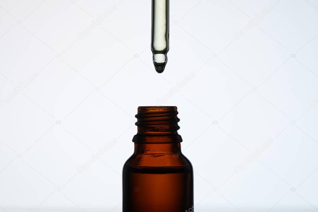 close-up shot of bottle of aromatic oil with pipette on white