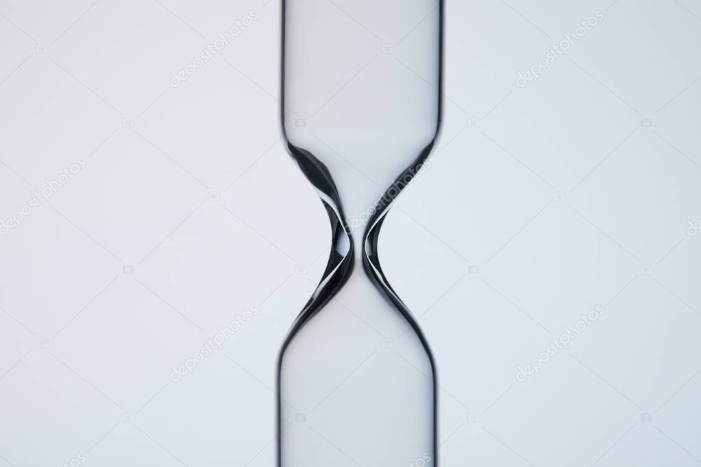 close-up shot of empty glasware in shape of hourglass on grey