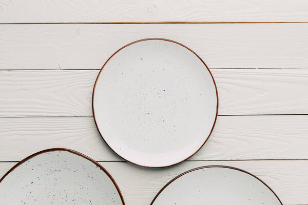 Пустые керамические плиты на белом деревянном фоне
