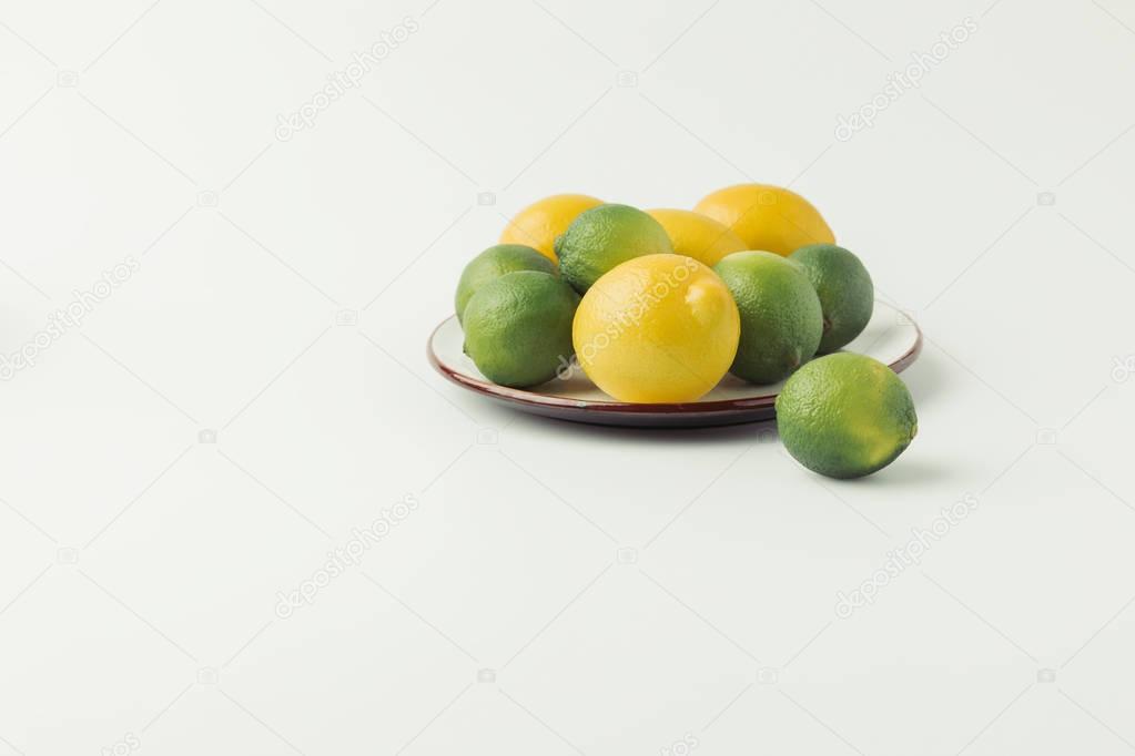 Citrus fruits on plate on white background