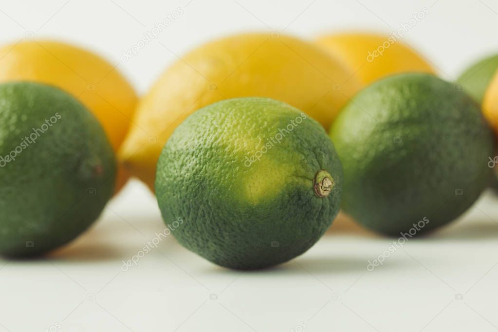 Raw limes and lemons isolated on white background