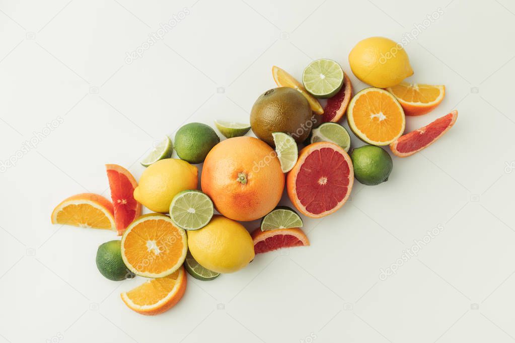 Pile of ripe lemons, limes, oranges and grapefruits  on white background