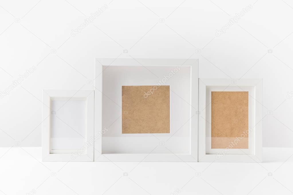 close-up view of various empty white photo frames on white  