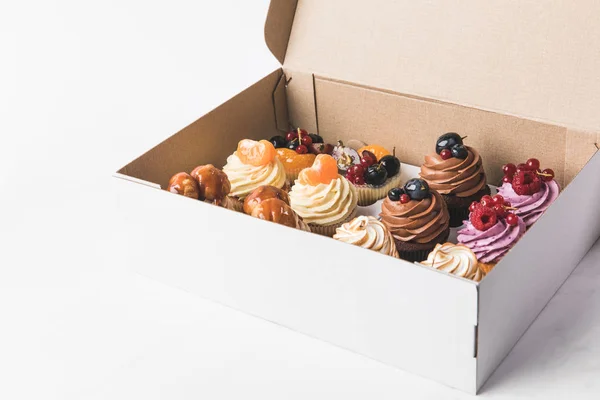 Vista Perto Vários Tipos Cupcakes Caixa Papelão Isolado Branco — Fotografia de Stock