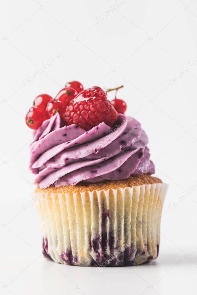 close up view of cupcake with cream and berries isolated on white