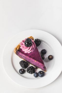 top view of sweet cake with fresh berries on plate isolated on white clipart