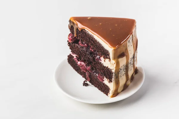 Закрыть Вид Сладкий Вишнево Шоколадный Торт Карамелью Тарелке Изолированной Белом — стоковое фото