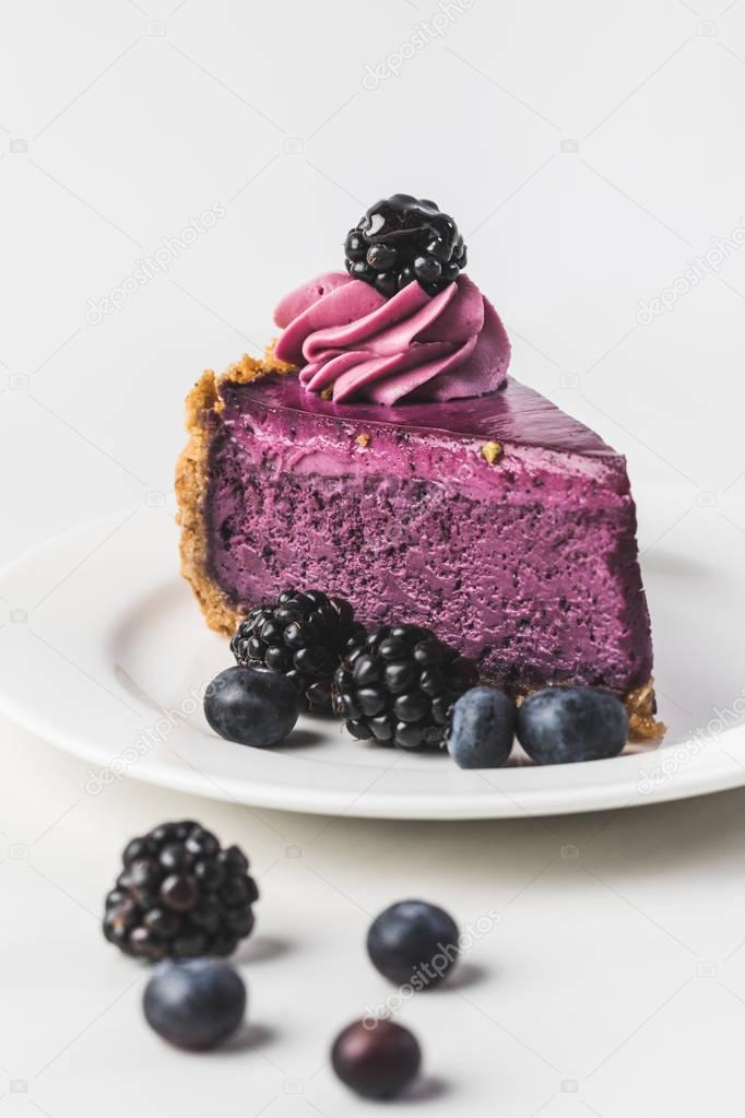close up view of sweet blueberrycake with fresh berries on plate isolated on white