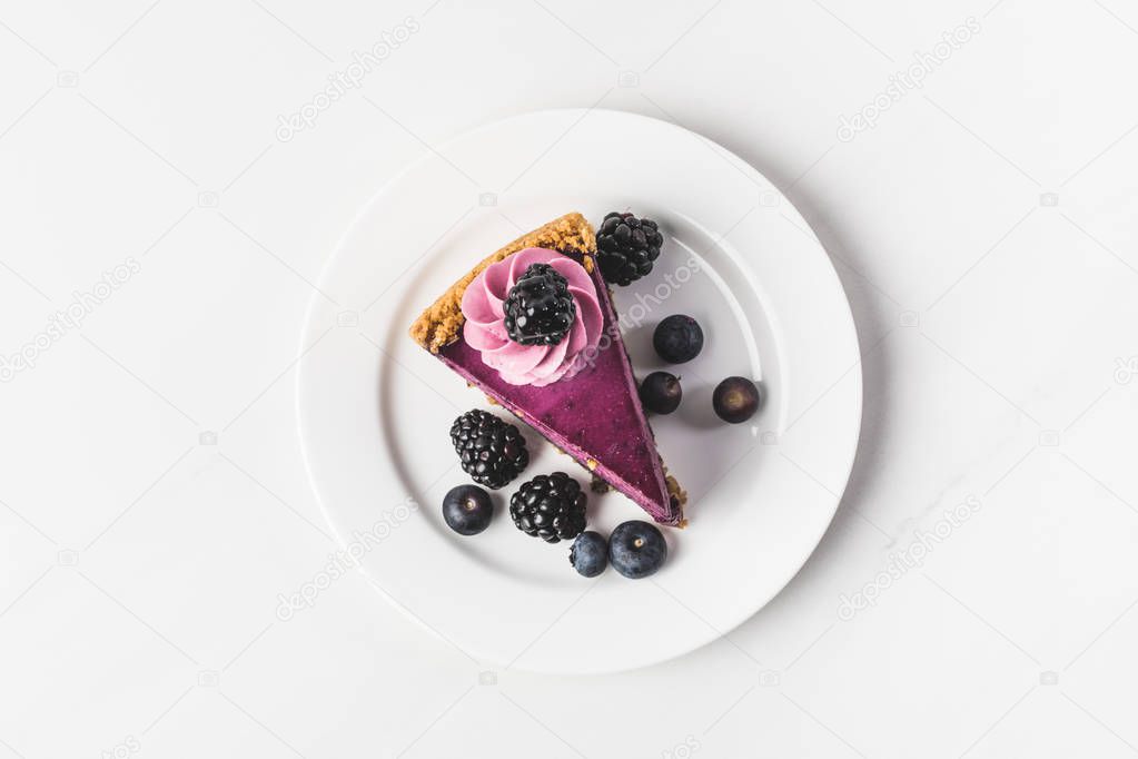 top view of blueberry cake with fresh berries on plate isolated on white