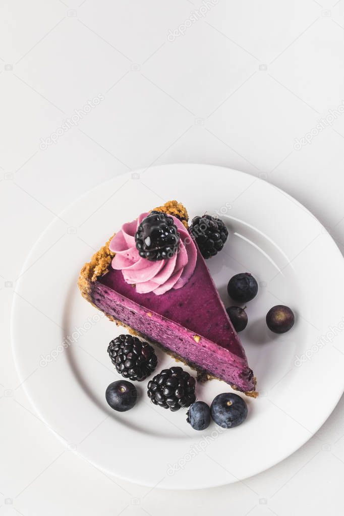 top view of sweet cake with fresh berries on plate isolated on white