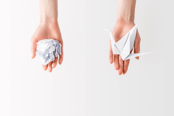 cropped shot of woman holding ball and bird made of paper in hands isolated on grey, environment and recycling concept