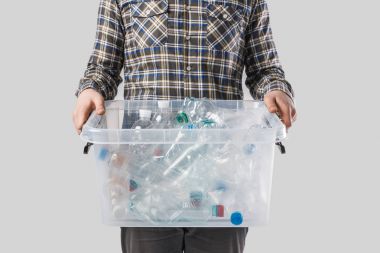 partial view of man holding container with plastic bottles in hands isolated on grey, recycling concept clipart