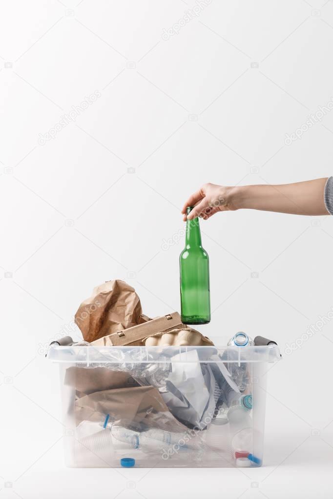 cropped shot of woman putting glass bottle into container with plastic bottles, recycle concept