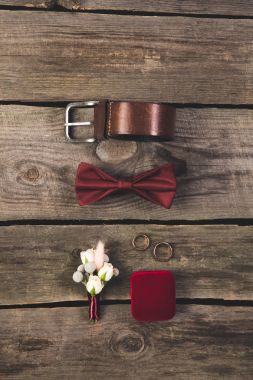 flat lay with arranged grooms accessories and wedding rings on wooden tabletop clipart