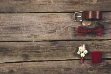flat lay with arranged grooms accessories and wedding rings on wooden tabletop clipart