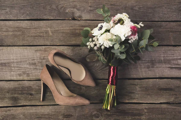 ブライダルの靴と木製のテーブルの上の美しい花束フラット レイアウト — ストック写真