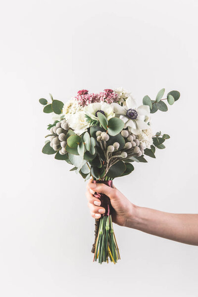 cropped shot of woman holding beautiful bridal bouquet isolated on grey