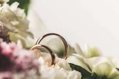 zblízka pohled na snubní prsteny, svatební kytice 