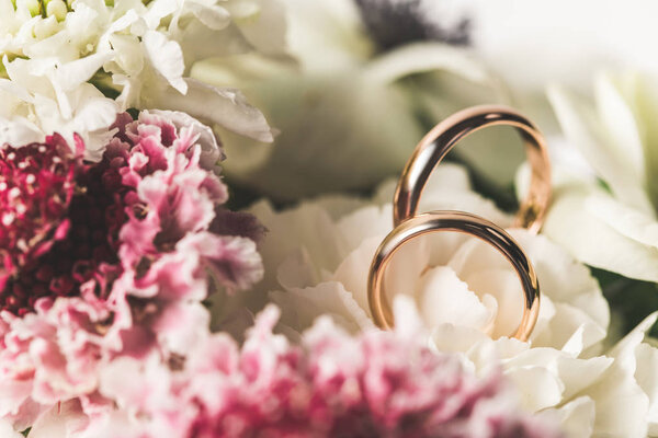 close up view of wedding rings in bridal bouquet 