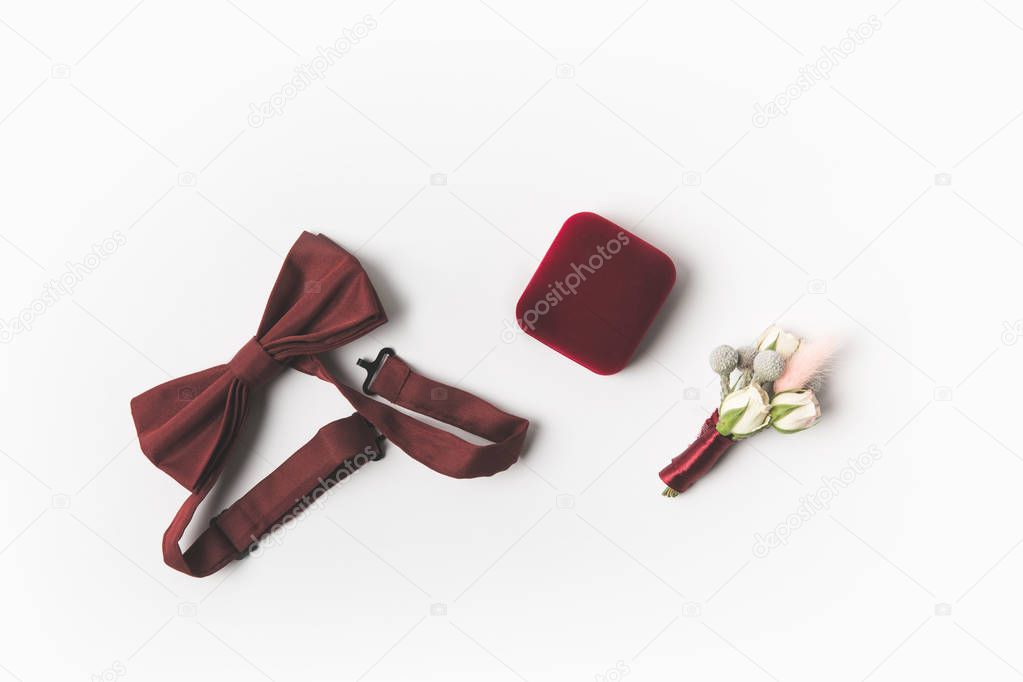 flat lay with buttonhole, bow tie and jewelry box isolated on white