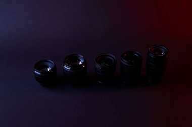 high angle view of row of camera lenses on dark surface clipart
