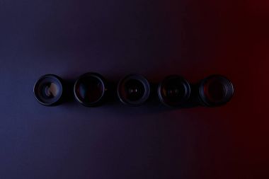 top view of row of camera lenses on dark clipart