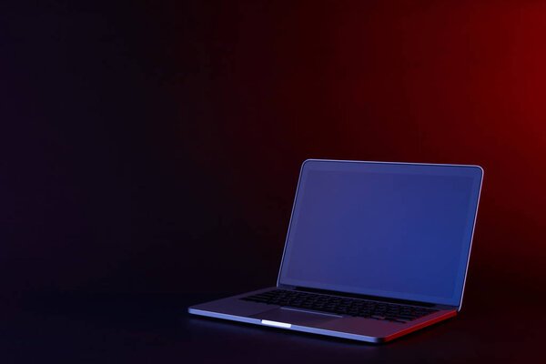 один открытый ноутбук с отражающим экраном на темной поверхности
