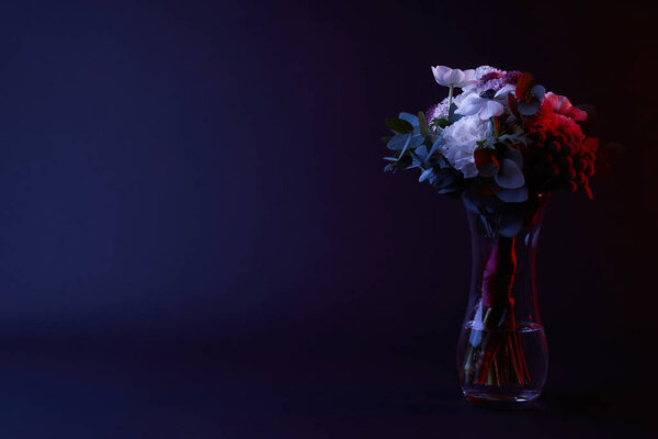 bouquet of different flowers in vase on dark