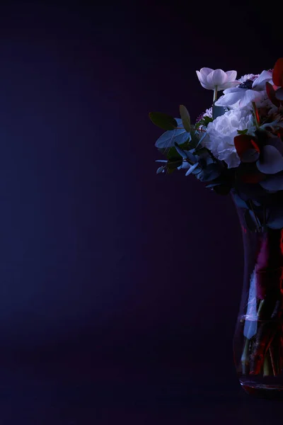 黑玻璃花瓶中不同花朵的花束 — 图库照片