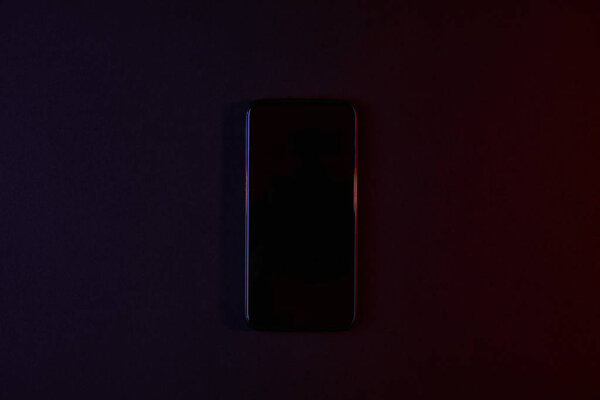 top view of black smartphone on dark