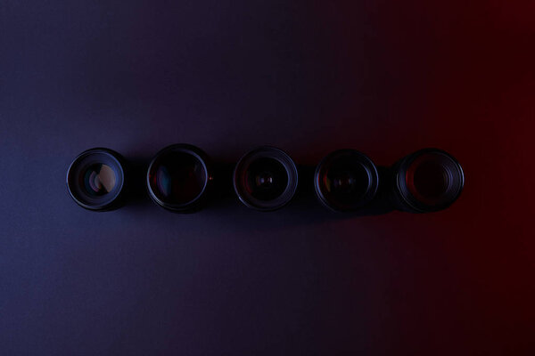 top view of row of camera lenses on dark