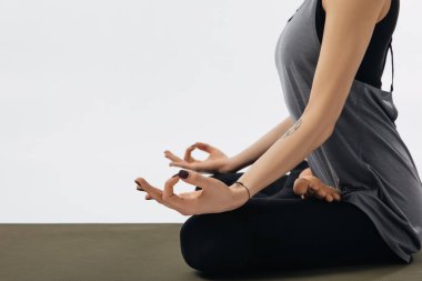 cropped image of woman meditating in yoga lotus pose isolated on white clipart