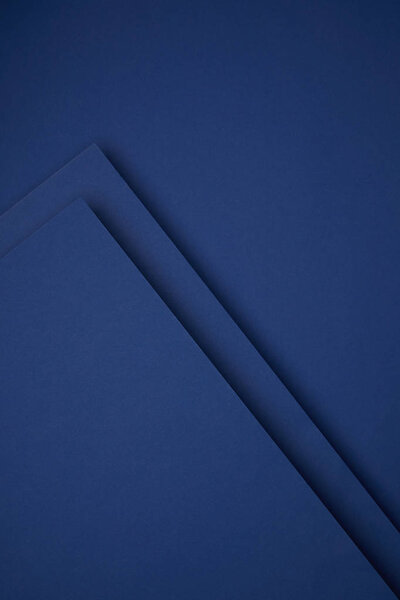 dark abstract background made from blue colored paper 