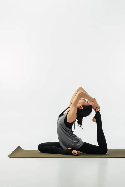 Donna Che Pratica Yoga Facendo Piccione Isolato Bianco — Foto Stock