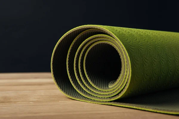 Green Rolled Yoga Mat Wooden Tabletop Black — Stock Photo, Image