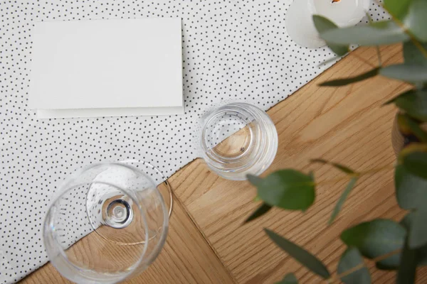 ブランク カードと花の横にあるテーブルの上のガラスのテーブルの設定 — ストック写真