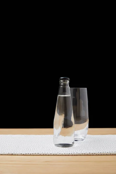 Botella Con Agua Vaso Vacío Sobre Mesa Sobre Fondo Negro — Foto de stock gratuita